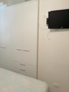 a bedroom with a dresser with a tv on a wall at Bilocale in pieno centro a Marettimo in Marettimo