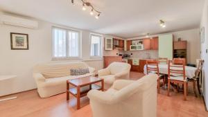 ein Wohnzimmer mit Stühlen und einem Tisch sowie eine Küche in der Unterkunft Ena in Novigrad Istria