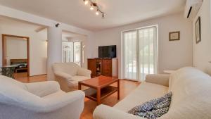 ein Wohnzimmer mit 2 weißen Sofas und einem TV in der Unterkunft Ena in Novigrad Istria