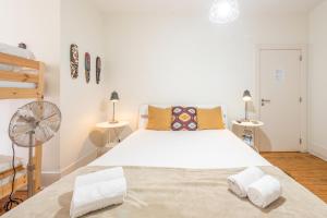 a bedroom with a large white bed and two lamps at Happy at Chiado in Lisbon