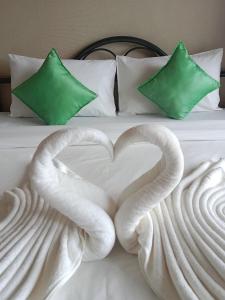 Dos cisnes haciendo un corazón en una cama en Fueangfu Home Hostel, en Chaweng