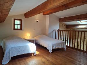 two beds in a room with wooden floors at La Croix du Sud - Ocres en Provence in Apt