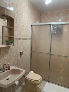 ein Bad mit einer Dusche, einem WC und einem Waschbecken in der Unterkunft Quarto Aconchego in Pomerode