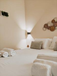 a white bedroom with two beds with towels on them at Domus Cese in Agrigento