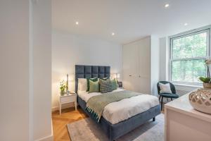 a bedroom with a large bed and a window at Superb 2 bed apartment near Camden Town FREE WIFI in London