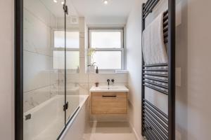 a bathroom with a sink and a tub and a shower at Superb 2 bed apartment near Camden Town FREE WIFI in London