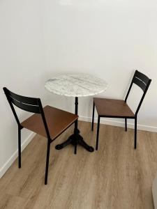 a table and two chairs next to a table and a table and chairs at Appartement Centre ville Le Havre in Le Havre