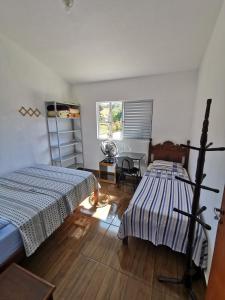 a bedroom with two beds and a desk and a window at Casa do Diogo in Capitólio