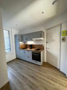 a kitchen with white cabinets and a stove top oven at Appartement Centre ville Le Havre in Le Havre
