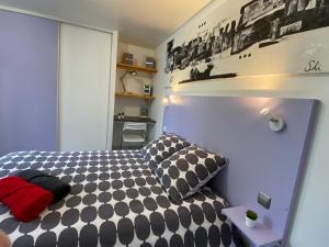 1 dormitorio con 1 cama con almohadas blancas y negras en Résidence Pierre François en La Roche-sur-Yon