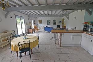 eine Küche und ein Wohnzimmer mit einem Tisch und Stühlen in der Unterkunft Le clos Hadrien Maison de campagne in Greuville