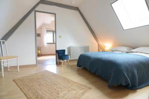 1 dormitorio con 1 cama con manta azul y espejo en Le clos Hadrien Maison de campagne, en Greuville