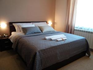 a bedroom with a large bed with two towels on it at B&B Vila Vidikovac in Arandjelovac