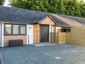 a house with a wooden garage with a door at Clonmore in Bodmin