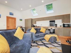 a living room with a blue couch and yellow pillows at Clonmore in Bodmin