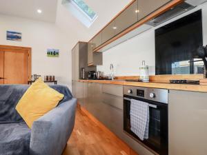a living room with a couch and a kitchen at Clonmore in Bodmin