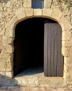 une porte en bois brun dans un bâtiment en pierre dans l'établissement Domaine de la Reynaude, à Aurons