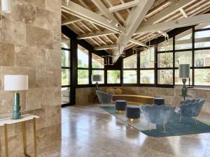 a lobby with a couch and chairs and windows at Domaine de la Reynaude in Aurons