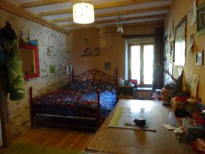 Schlafzimmer mit einem Bett und Holzboden in der Unterkunft Maison de charme à Saoû, avec beau jardin au calme in Saou