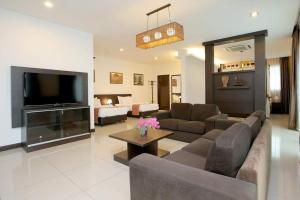 a living room with a couch and a tv at Ipoh Downtown Hotel in Ipoh