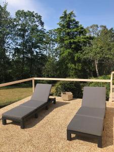 deux chaises et un banc sur une terrasse dans l'établissement Maison Nature Bretagne 3 chambres Plain-Pied, à Langonnet
