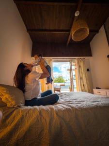 una mujer sentada en una cama sosteniendo a un niño en El Destino Casa de Descanso en Tandil