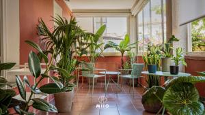 a room filled with lots of plants and tables and chairs at MIIO HOTEL in San Vincenzo