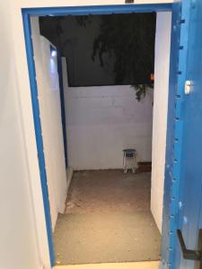 una puerta azul que conduce a una habitación con silla en The Blue Gate 6, en Mascate