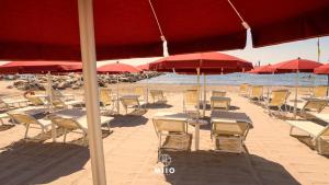 a bunch of chairs and umbrellas on a beach at MIIO HOTEL in San Vincenzo