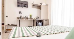 a bedroom with a large bed and a kitchen at MIIO HOTEL in San Vincenzo