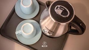 a tea kettle and cups on a tray at MIIO HOTEL in San Vincenzo