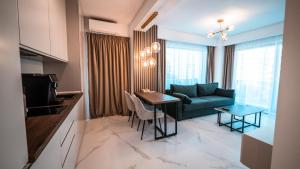 ein Wohnzimmer mit einer grünen Couch und einem Tisch in der Unterkunft WAVE 4 Apartments Mamaia Nord in Năvodari