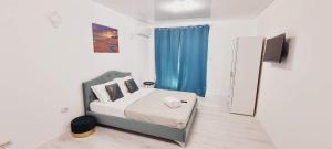 a small bedroom with a bed and a television at Vila LaDom Etajul 1 in Mamaia Sat/Năvodari