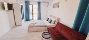 a bedroom with a bed and a couch and blue curtains at Vila LaDom Etajul 1 in Mamaia Sat/Năvodari