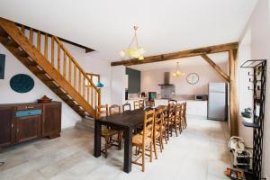 een keuken en eetkamer met een houten tafel en stoelen bij Moulin du Ruet in Saint-Amand-sur-Fion