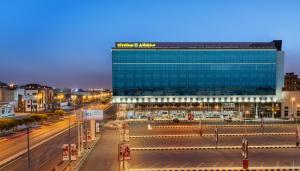 a large glass building on a city street at night at Nivel Hotel in Khamis Mushayt