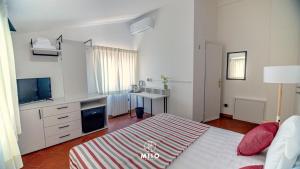 a bedroom with a bed and a desk and a television at MIIO HOTEL in San Vincenzo