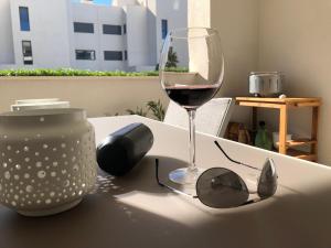 een glas wijn en een zonnebril op een tafel bij Modern 2 bedroom ground Apartment at Alhaurin Golf in Alhaurín el Grande