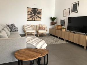 een woonkamer met een bank en een flatscreen-tv bij Modern 2 bedroom ground Apartment at Alhaurin Golf in Alhaurín el Grande