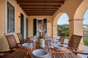 un lungo tavolo in legno con piatti e bicchieri su un patio di Villa Ardea a Soiano del Lago