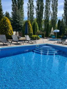 a swimming pool with chairs and a swimming pool at In hotel in Kamianets-Podilskyi