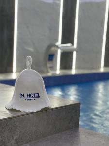 un sombrero blanco sentado en un mostrador junto a una piscina en In hotel en Kamianets-Podilskyi