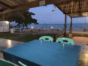 柴老海灘的住宿－บ้านพักวิตามินซี จันทบุรี，海滩前的蓝色桌椅