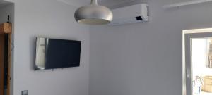 Elle comprend une télévision à écran plat suspendue sur un mur blanc. dans l'établissement Alojamento Local - Covas, à Santiago do Cacém