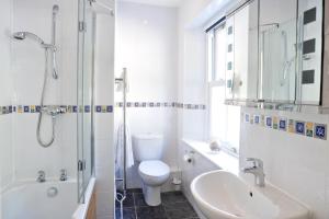 a bathroom with a toilet and a sink and a shower at Penryn House Hotel in Polperro
