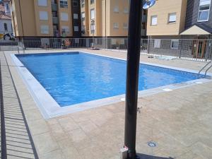 a large swimming pool with a pole in front of a building at Apartamentos DEVA in Unquera