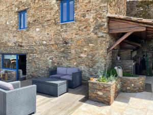 un patio con muebles y un edificio de ladrillo en Campus Natura, en Arganil