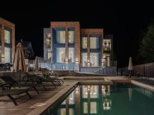a hotel with a swimming pool at night at Aurora Luxe in Dilijan