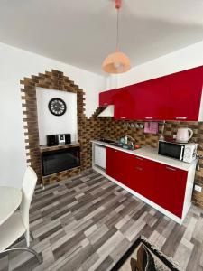 una cocina con armarios rojos y un reloj en la pared en Апартаменти в центрі Трускавця, en Truskavets