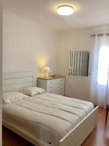 Un dormitorio blanco con una cama grande y una ventana. en Azores Terrace Apartment T2, en Ponta Delgada